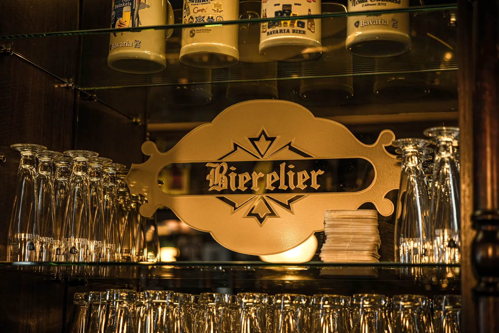 Het verlichte Bierelier bord boven de bar