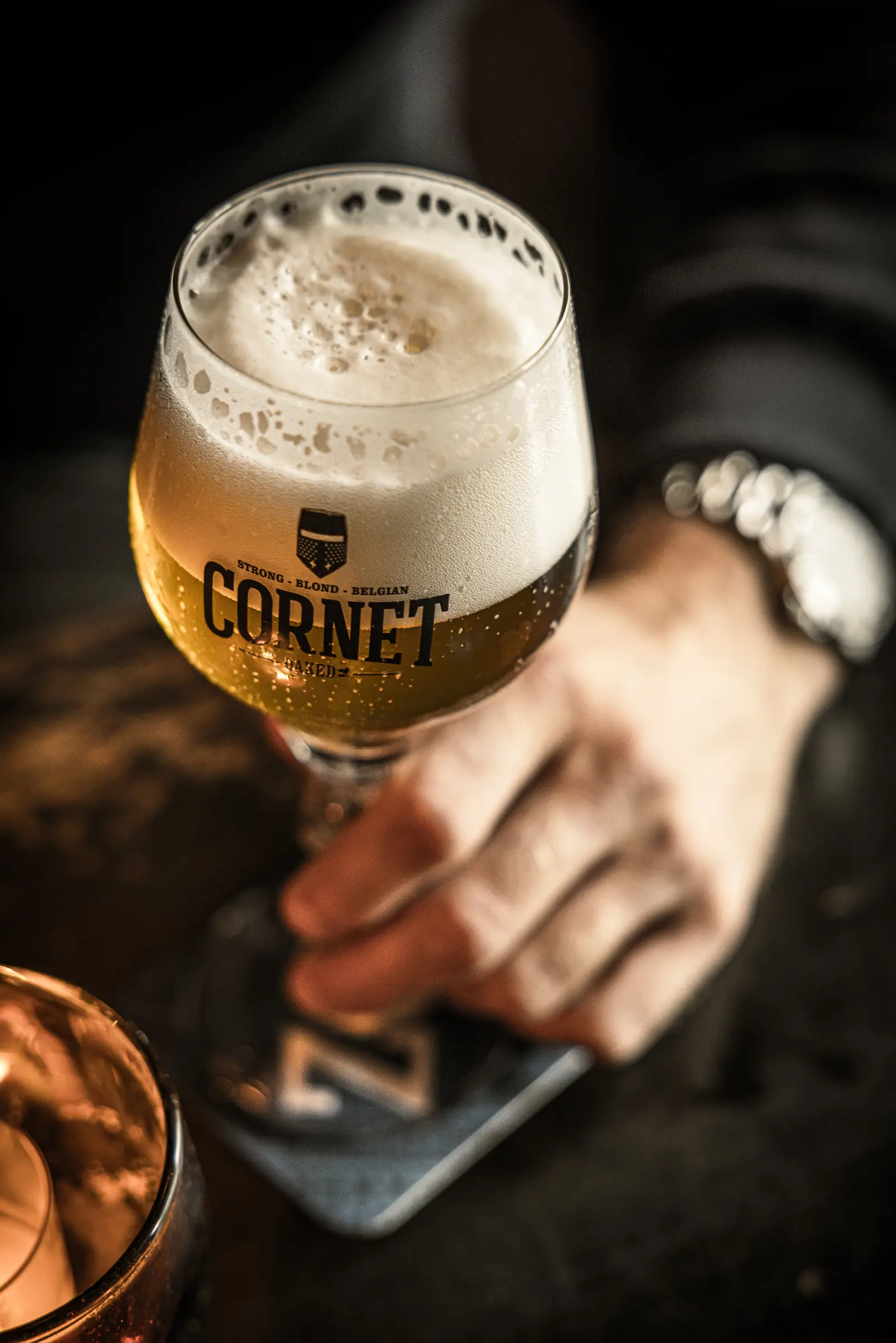 Een gevuld bierglas in de hand