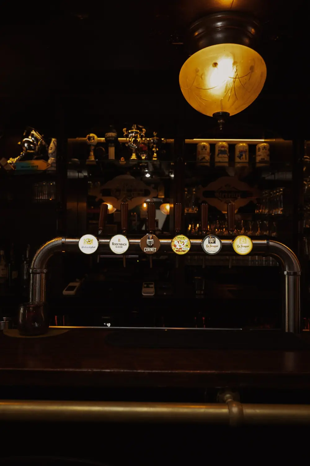 De taprij onder de koperen lamp in het cafe